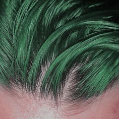 a person with green hair is shown from the top down and has long, straight bangs