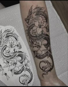 a dragon and flower tattoo on the left arm, next to a drawing of a snake