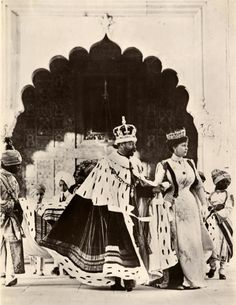 an old black and white photo of two women dressed in historical clothing standing next to each other