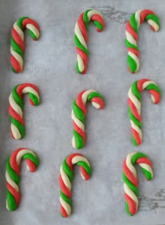 candy canes are arranged in the shape of letters on a sheet of baking paper