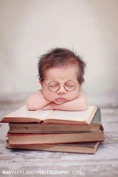 a baby wearing glasses laying on top of a book with the words dolce note