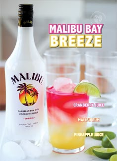 a bottle of malbu bay breeze next to two glasses filled with ice and limes