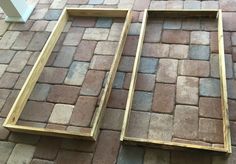 two wooden frames sitting on top of a brick floor