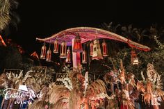 an elaborately decorated building at night with palm trees and lights on it's sides