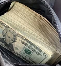 an open backpack filled with money sitting on top of it