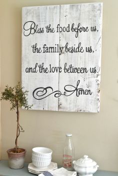 a wooden sign that says, blessing the food before us and the family beside us and the love between us