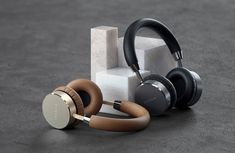 headphones are sitting on top of each other in front of an object that looks like a cube