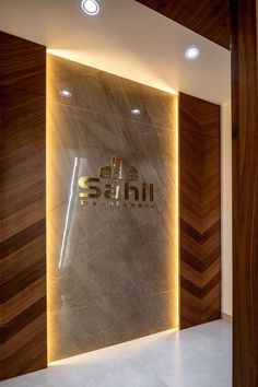 the entrance to sahii is lit up by recessed lighting and wood paneling