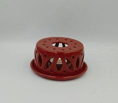 a red candle holder sitting on top of a white table