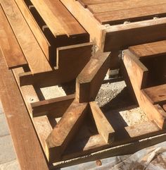 several pieces of wood sitting on top of a brick floor next to a stone walkway