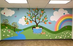 an empty room with a mural on the wall and two children reading books under a tree