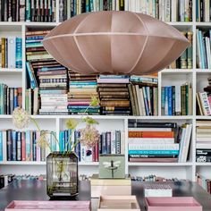 a room filled with lots of books and a lamp