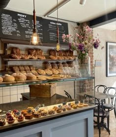 a bakery filled with lots of pastries on display next to a table full of flowers