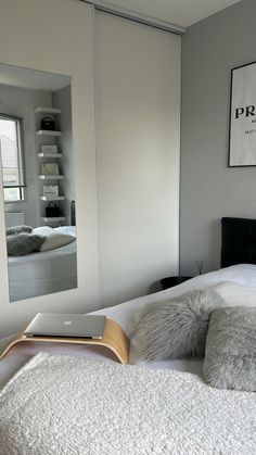 a bedroom with a book on the bed and a mirror in the wall above it