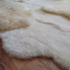 a large white rug on top of a wooden floor