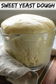 a loaf of bread sitting in a glass bowl on top of a wooden cutting board