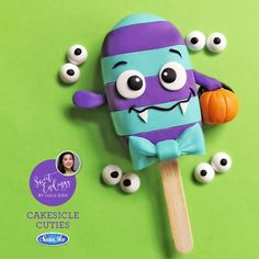 an ice cream pops with googly eyes and a purple monster on it's stick