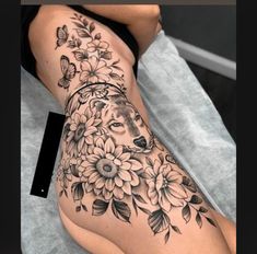 a woman's thigh with flowers and a wolf on it