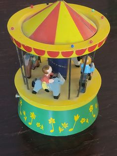 small toy figurines sitting on top of a carousel