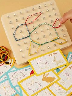 a child's hand is playing with an activity board