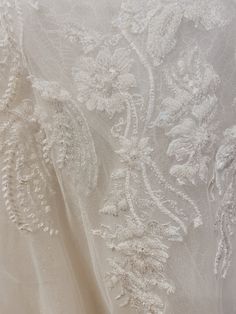 the back of a wedding dress with white lace