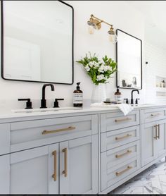 a bathroom with double sinks and mirrors on the wall, along with marble flooring