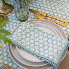 a table set with place settings and gold utensils