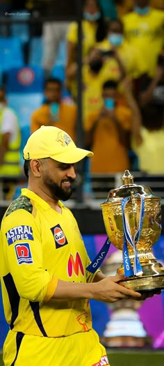 a man in yellow uniform holding up a trophy