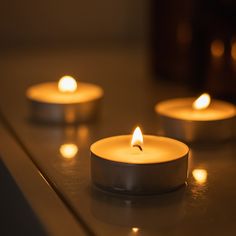 three lit candles sitting on top of a counter