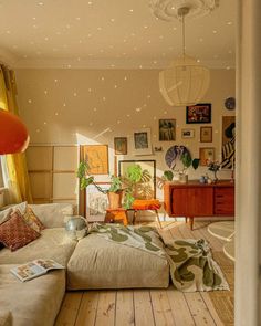 a living room filled with furniture and lots of pictures hanging on the wall above it