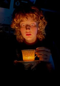 a person holding a cup in the dark