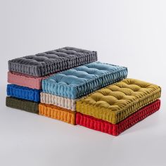 four different colored cushions stacked on top of each other