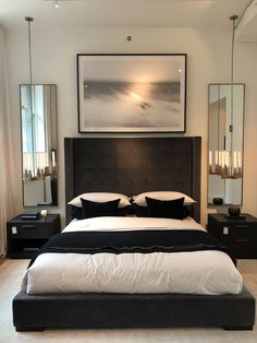 a large bed sitting in a bedroom next to two nightstands and a painting on the wall