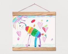 a child's drawing hanging on a wall with hearts and an umbrella in the background