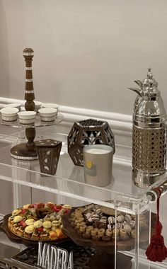 an assortment of desserts are displayed on a clear shelf