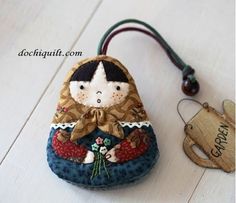 a small purse with a doll hanging from it's side on a wooden table