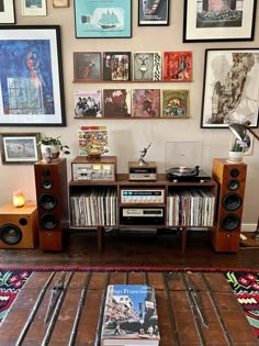 there are many pictures on the wall above this entertainment center with speakers and bookshelves