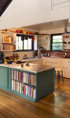 a kitchen with an island and lots of books on the shelves in front of it