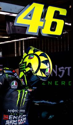 a man wearing a helmet and gloves with the number 46 monster energy on it