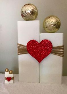 two white boxes with red and gold decorations on top of each other, one is shaped like a heart