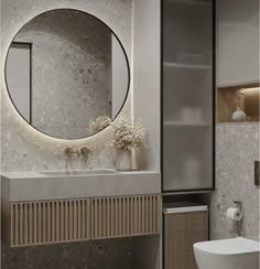 a white sink sitting under a round mirror in a bathroom