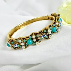 This stunning vintage Florenza bracelet is in excellent condition. NO missing beads, stones or crystals.  The latch opens and closes easily and has an added chain for added security. It is in a gold tone metal and accented with turquoise and cream coloured pearls. The underside of the bracelet has engraved flowers and leaves that decorate the band. This wonderful piece of vintage jewellery is elegant and fun at the same time. Would look great with any dressy outfit but also goes great with jeans Vintage Jeweled Bracelets For Wedding, Vintage Beaded Wedding Bracelets, Adjustable Vintage Beaded Bracelet For Wedding, Vintage Adjustable Jeweled Bracelets, Adjustable Vintage Jeweled Bracelets, Vintage Beaded Bangle Bracelet, Vintage Beaded Bangle Bracelets, Vintage Turquoise Bracelets As Gift, Vintage Beaded Bangle Bracelets For Party