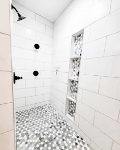 a white tiled bathroom with black and white tiles on the shower wall, floor and ceiling