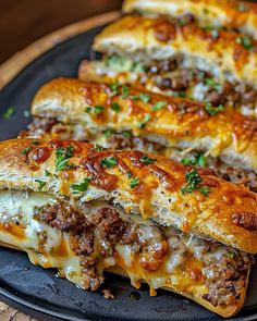 some meat and cheese bread on a black plate