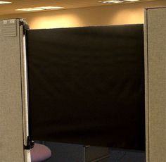 an office cubicle with a black screen behind it