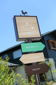 a wooden sign with several different signs on it's post in front of a building