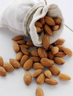 almonds spilling out of a bag on a white surface