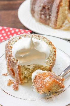 a piece of cake on a white plate with a fork and some whipped cream in it