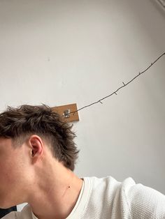 a man is cutting the hair off of his head with a pair of clothes pins