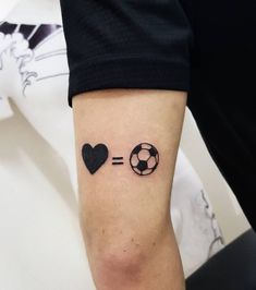 a person with a soccer ball and heart tattoo on their arm